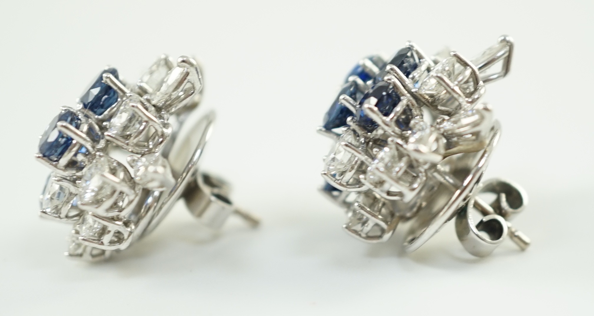 A pair of modern 750 white gold, set sapphire and diamond cluster ear studs